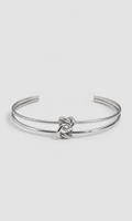 A silver-toned open cuff bangle bracelet featuring a textured rope-style band and a polished central knot detail, shown on a light gray background.