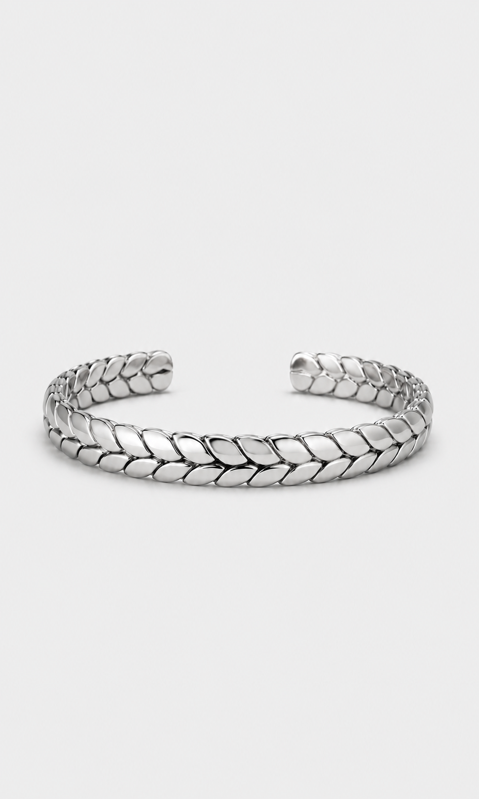 A silver-toned metal cuff bracelet with a textured, woven leaf-like pattern, displayed on a light gray background.