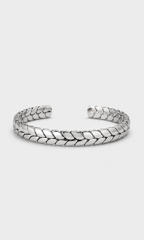 A silver-toned metal cuff bracelet with a textured, woven leaf-like pattern, displayed on a light gray background.
