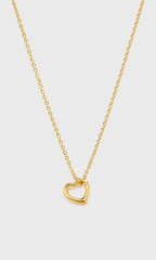 A delicate gold chain necklace featuring a small, polished open heart pendant, displayed against a clean, light gray background.