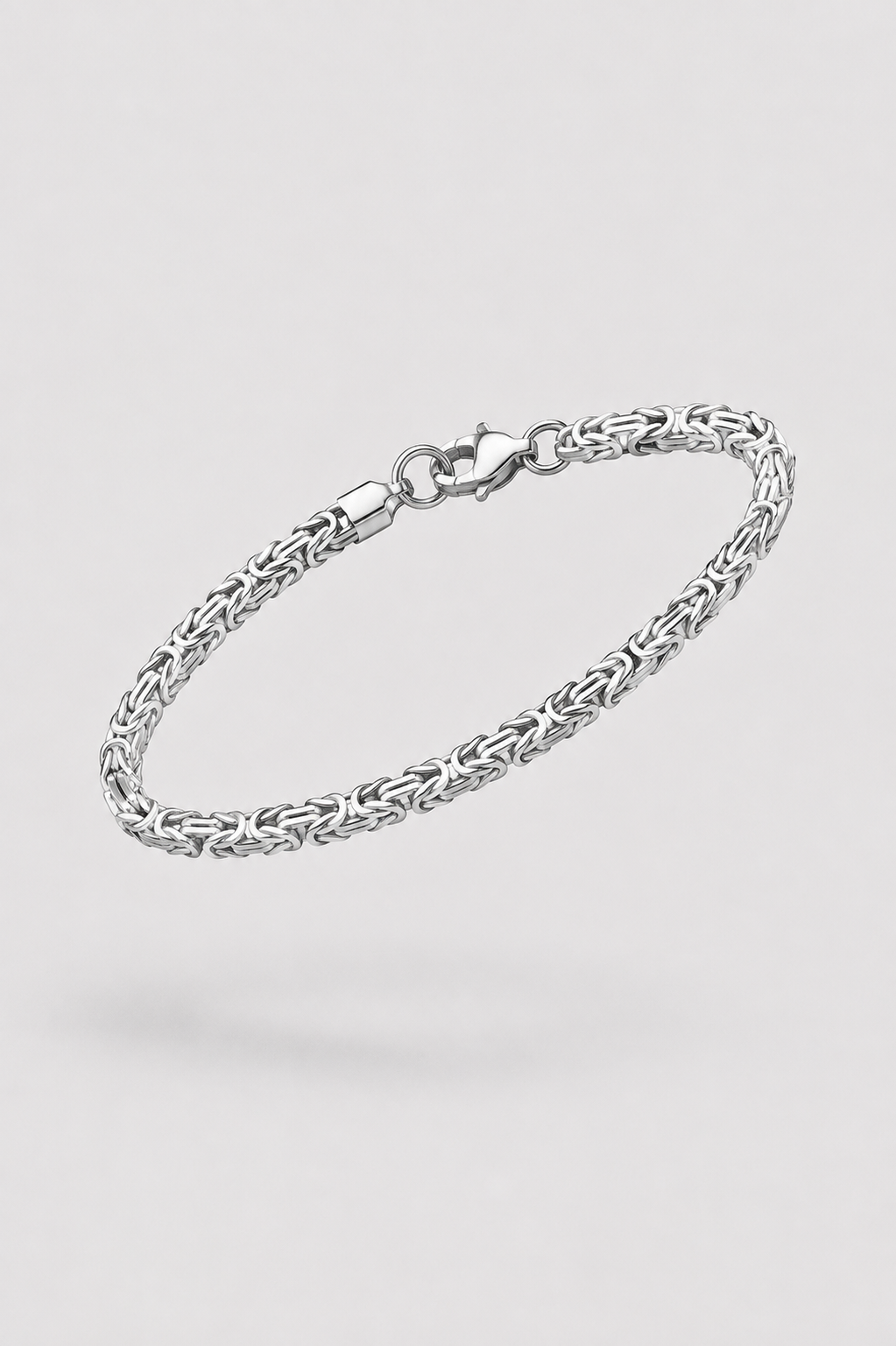 A silver-toned metal chain bracelet with a lobster clasp, shown floating against a light gray background.