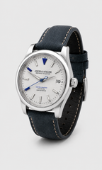 AneesaAtelier Automatic watch with a silver stainless steel case, white dial with blue accents, and a dark navy blue leather strap with tan contrast stitching, shown on a light gray background.