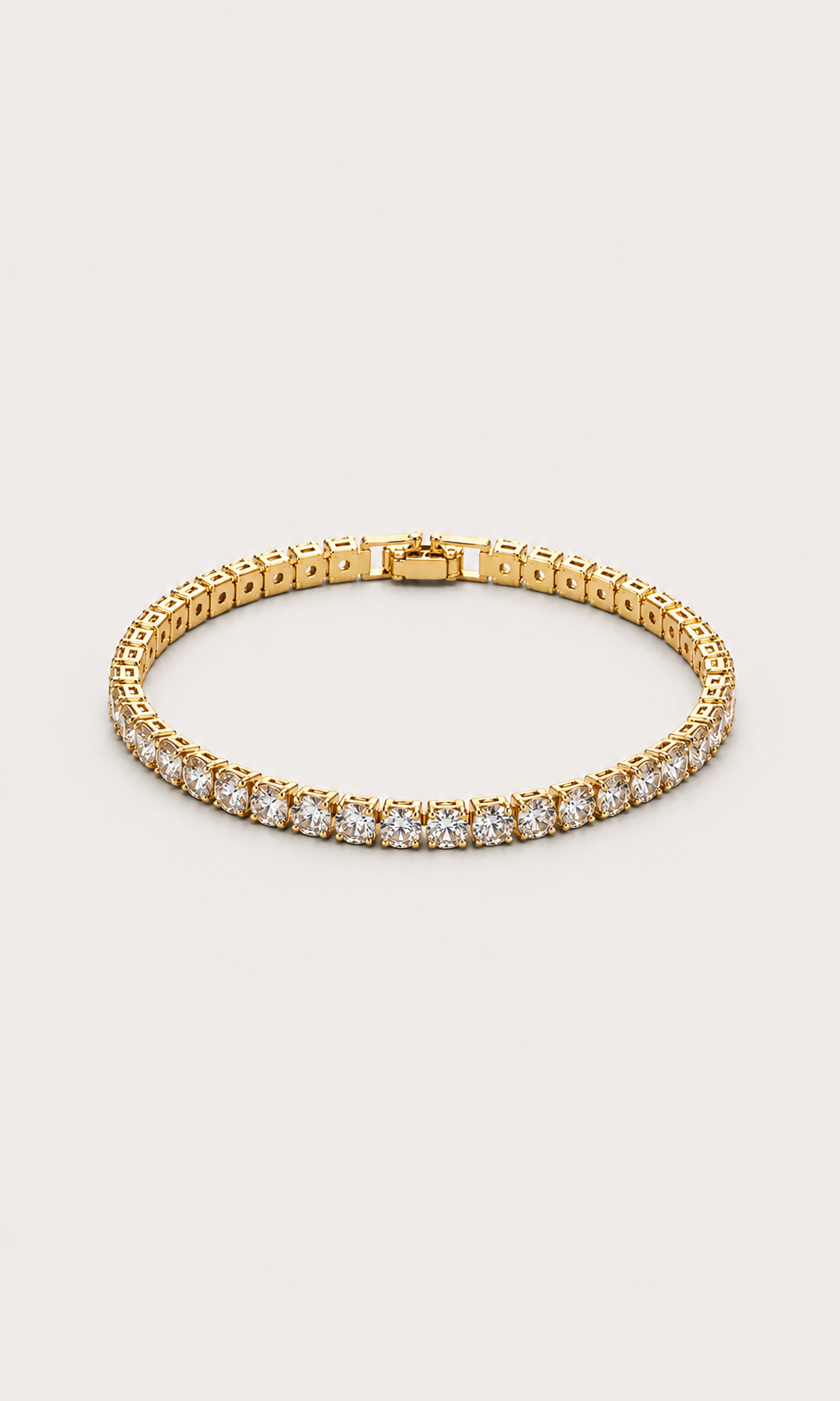A gold tennis bracelet with a row of clear gemstones along the front, displayed on a light beige background.