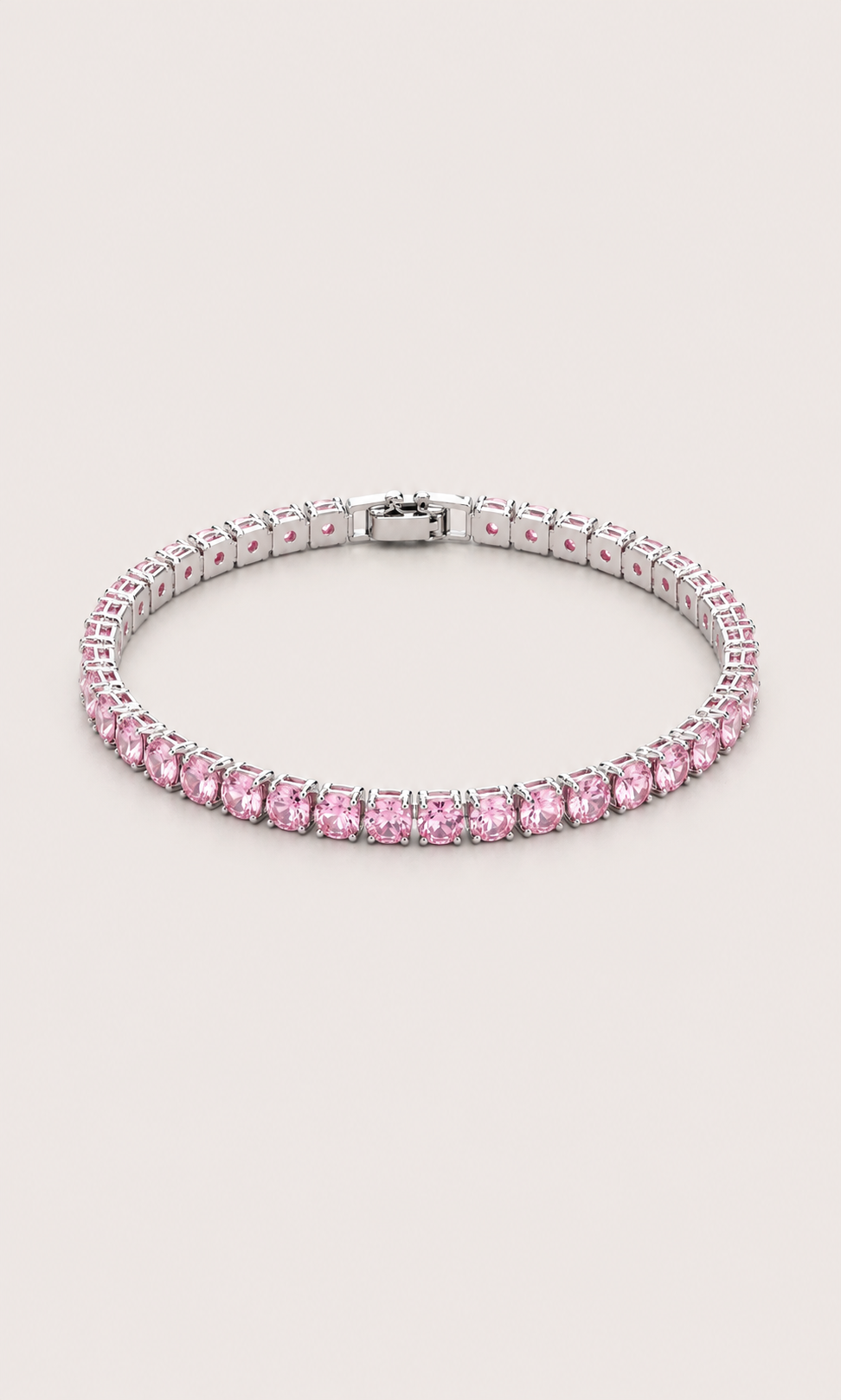 A tennis bracelet featuring round pink gemstones in a silver-toned setting, displayed on a light beige background.
