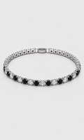 A tennis bracelet with alternating round black and clear stones in a silver-toned setting, shown against a light gray background.