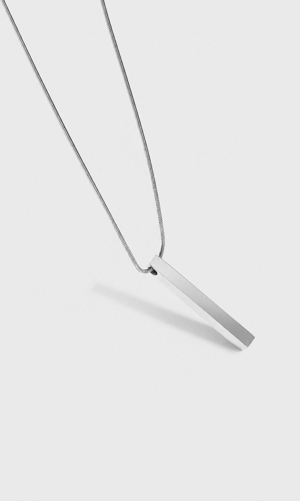 Shop the ANEESA Monolith — a silver bar pendant necklace on a 50cm snake chain. Minimalist stainless steel design, built for everyday wear.