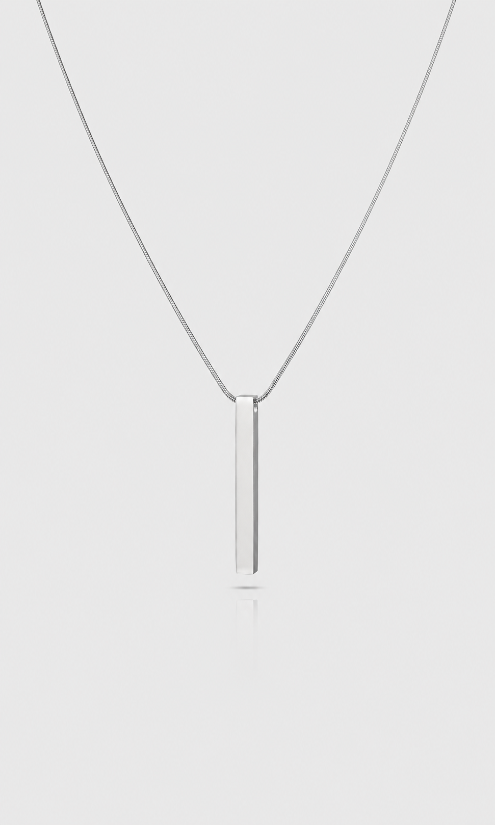 Shop the ANEESA Monolith — a silver bar pendant necklace on a 50cm snake chain. Minimalist stainless steel design, built for everyday wear.