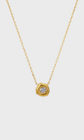 A gold chain necklace with a hexagonal pendant featuring a clear round gemstone, shown against a light gray background.