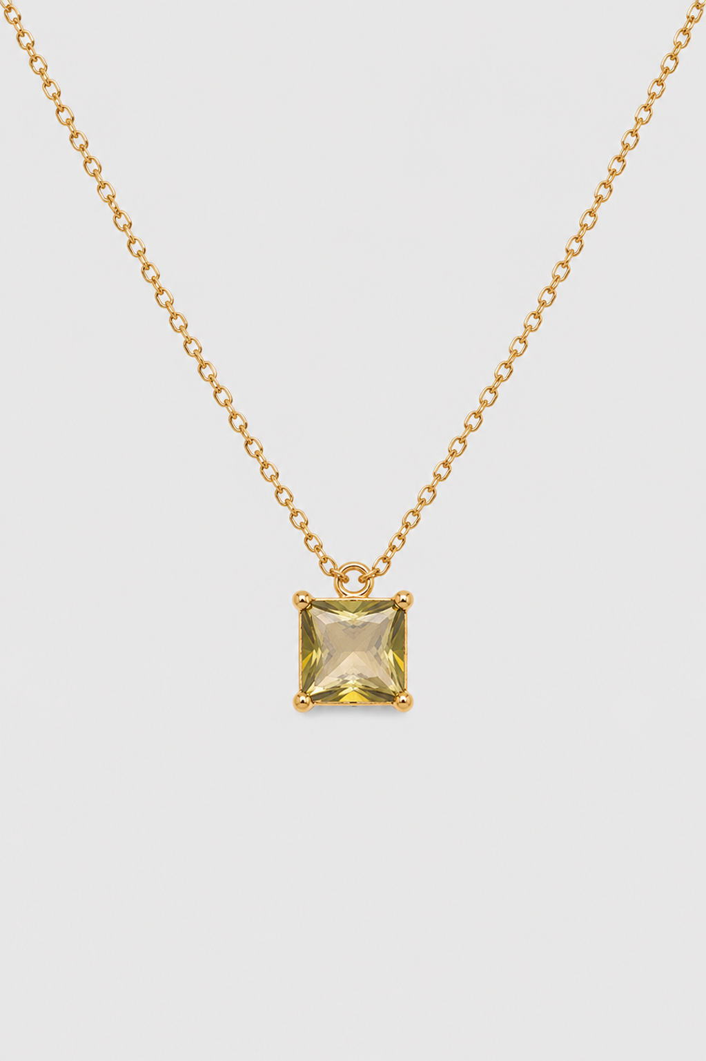 A gold chain necklace with a small square yellow gemstone pendant, displayed against a light gray background.