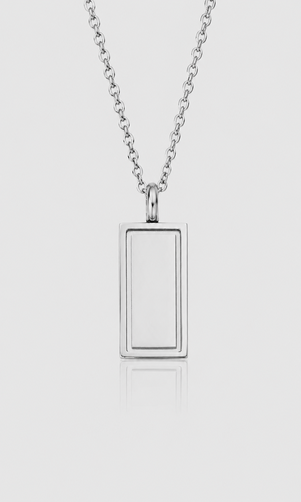 A silver-toned rectangular pendant necklace with a smooth, polished finish, suspended from a matching chain against a light gray background.