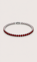 A silver tennis bracelet featuring round-cut red gemstones, displayed on a light beige background.