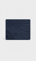 A navy blue leather card holder wallet by Anesa, featuring an embossed coastal landscape design and the brand name 'ANESA' near the bottom, set against a light gray background.