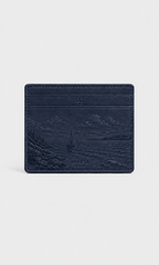 A navy blue leather card holder wallet by Anesa, featuring an embossed coastal landscape design and the brand name 'ANESA' near the bottom, set against a light gray background.