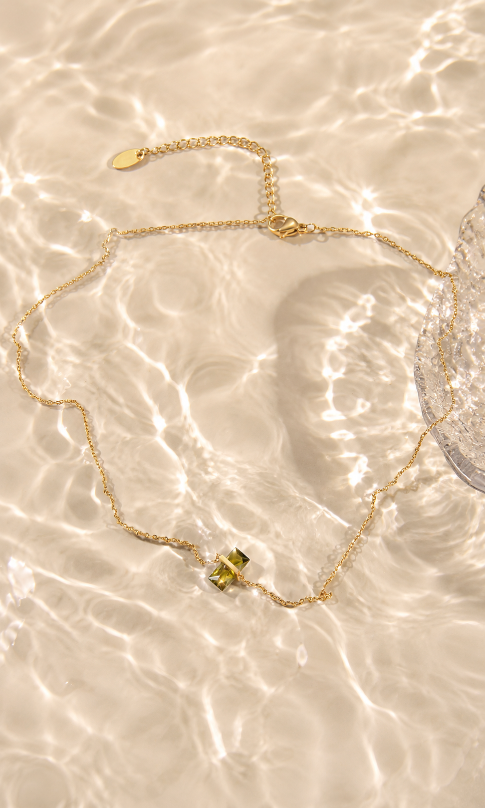 A delicate gold chain necklace with a small gold bow charm, 