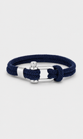 A navy blue braided rope bracelet with a silver-toned buckle and knot closure, displayed on a light gray background.